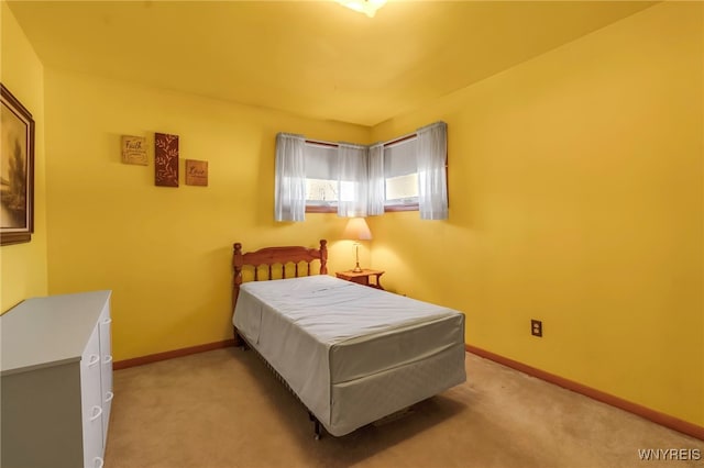 bedroom with light colored carpet and baseboards