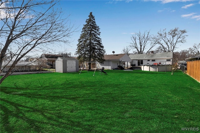 view of yard with an outbuilding, a fenced backyard, and a shed