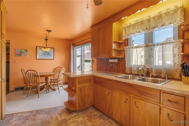 kitchen with visible vents, open shelves, a peninsula, a sink, and light countertops