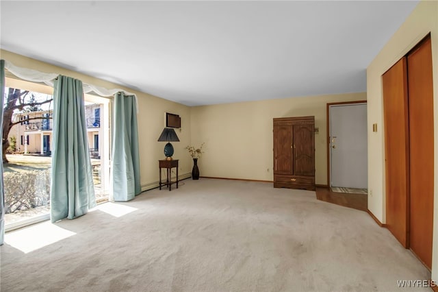 spare room featuring a baseboard radiator, baseboards, and carpet flooring