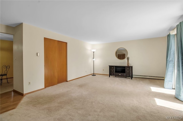 living room with baseboard heating, carpet flooring, and baseboards