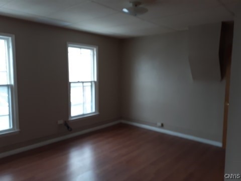 empty room featuring wood finished floors and baseboards