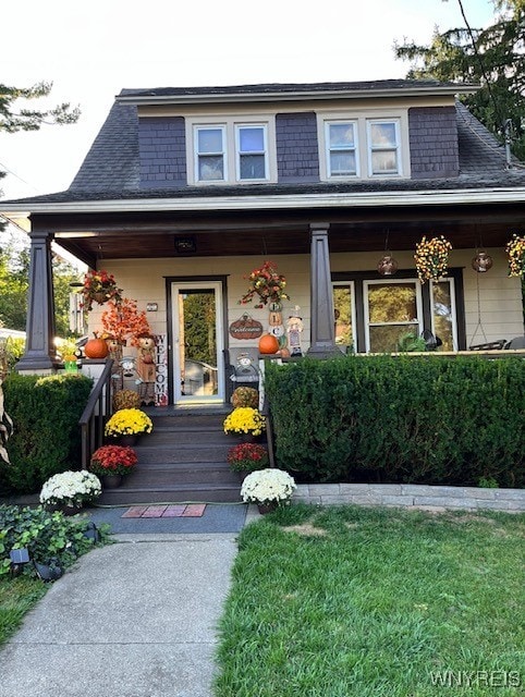 exterior space with a porch and a shingled roof