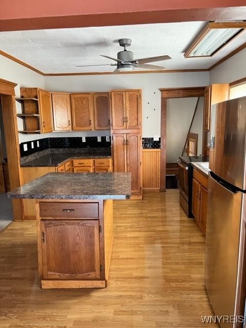 kitchen with range with electric cooktop, a kitchen island, freestanding refrigerator, light wood-style floors, and open shelves