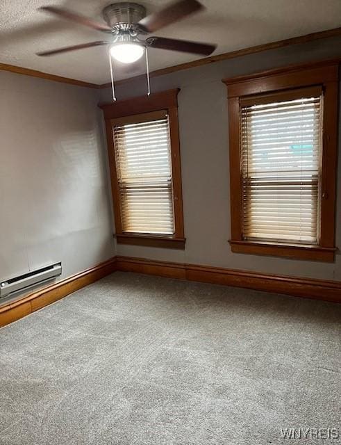 carpeted empty room featuring ceiling fan, baseboards, plenty of natural light, and ornamental molding