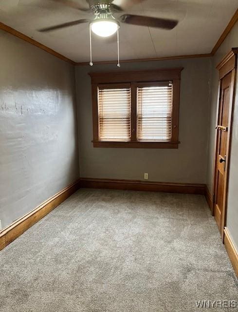 spare room featuring light carpet, baseboards, ceiling fan, and ornamental molding