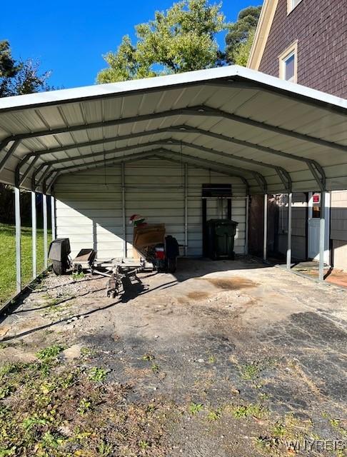 view of parking with a detached carport and driveway