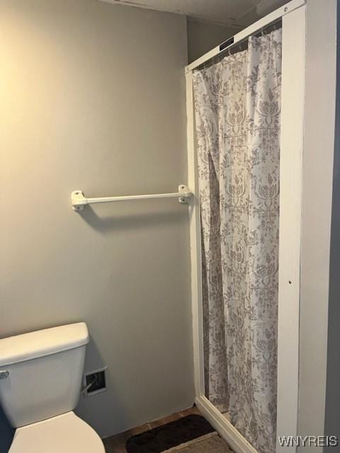 bathroom with curtained shower and toilet