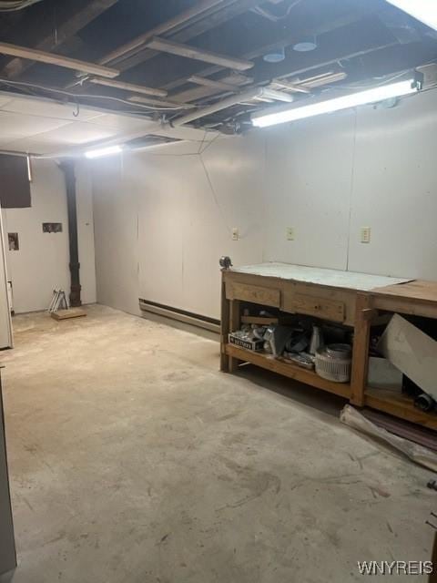 unfinished basement with a workshop area and baseboard heating