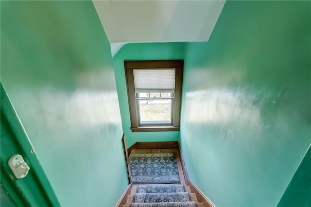 stairway with lofted ceiling and baseboards