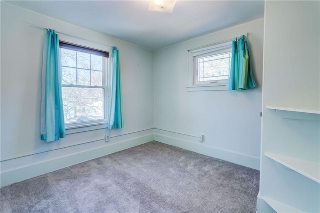 spare room featuring baseboards and carpet floors