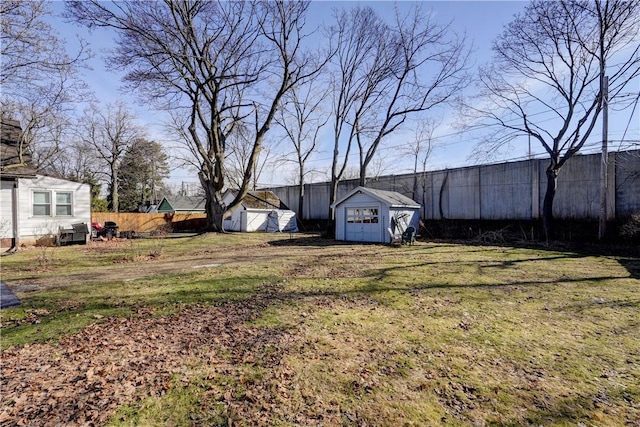 view of yard with an outbuilding, a shed, and fence