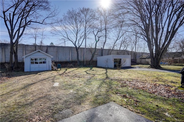 view of yard featuring an outdoor structure, fence, and a garage