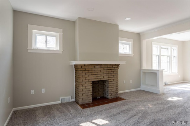 unfurnished living room with visible vents, baseboards, a brick fireplace, and carpet flooring