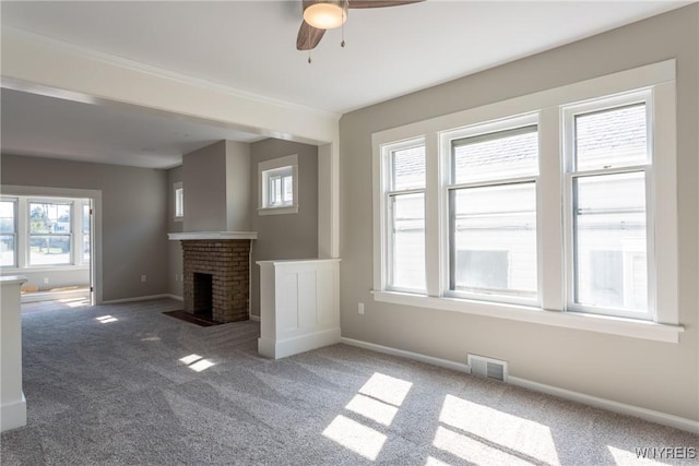 unfurnished living room featuring visible vents, baseboards, carpet, and a brick fireplace