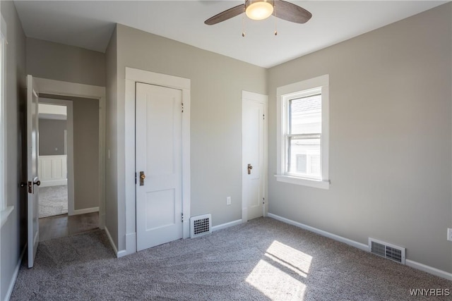 unfurnished bedroom with visible vents, baseboards, and carpet flooring