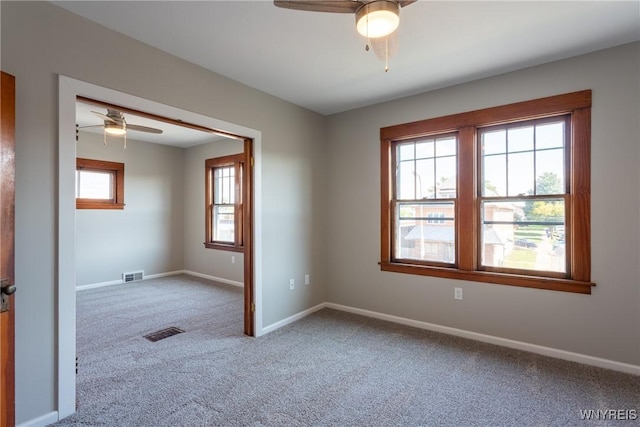 spare room featuring visible vents, carpet flooring, and baseboards