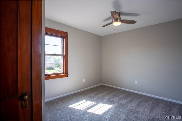 carpeted spare room with baseboards and ceiling fan