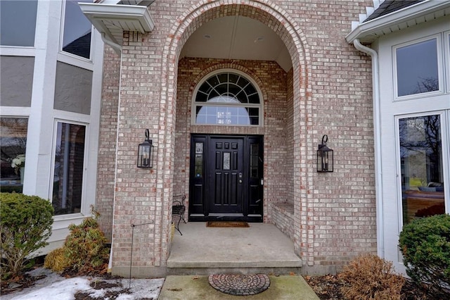 doorway to property featuring brick siding