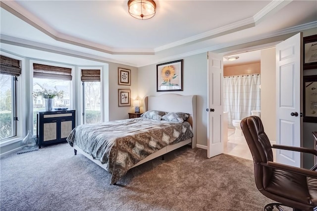 carpeted bedroom with visible vents, ensuite bath, crown molding, a raised ceiling, and access to outside