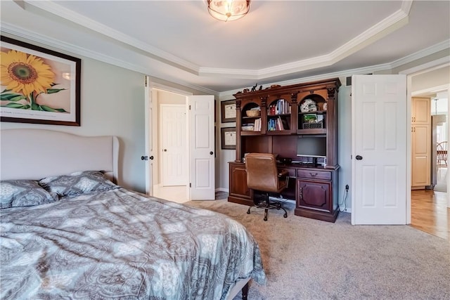 carpeted bedroom featuring a tray ceiling and crown molding