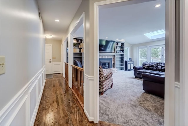 hallway with recessed lighting, vaulted ceiling with skylight, and carpet