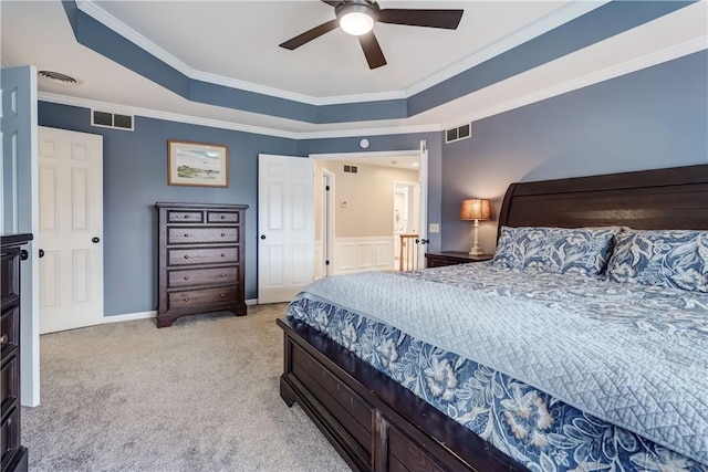 bedroom featuring a tray ceiling, visible vents, ornamental molding, and carpet flooring