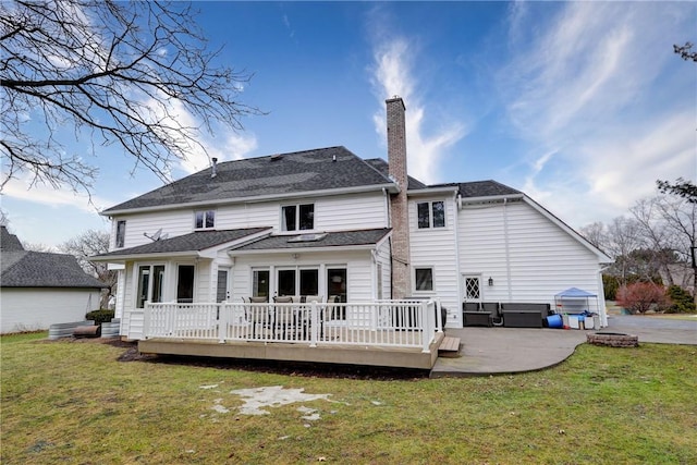 back of house featuring a patio, a wooden deck, a lawn, and a chimney