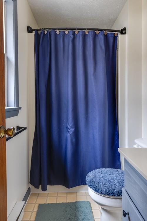 bathroom with vanity, a shower with shower curtain, toilet, and a textured ceiling