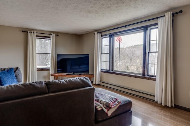 living area featuring plenty of natural light, a textured ceiling, and wood finished floors