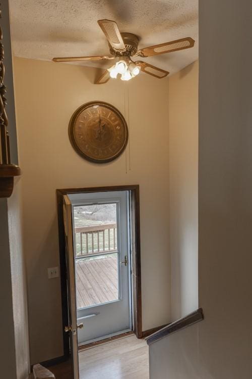 entryway featuring ceiling fan, light wood-style flooring, and a textured ceiling