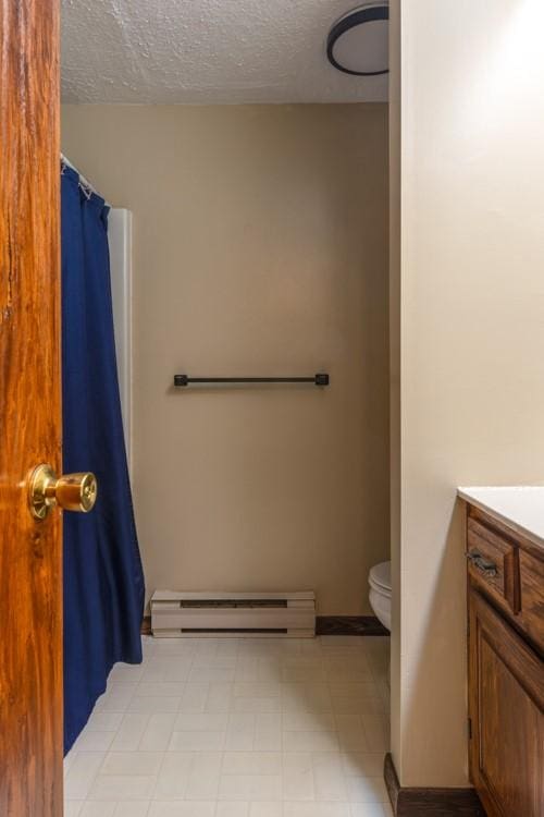 full bathroom with vanity, a textured ceiling, tile patterned floors, toilet, and baseboard heating