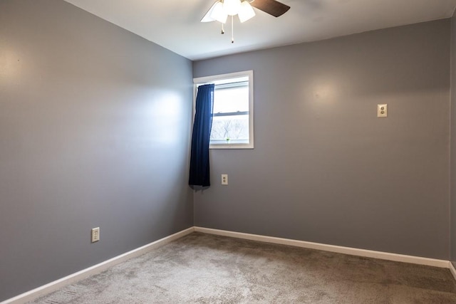 spare room with carpet flooring, baseboards, and ceiling fan