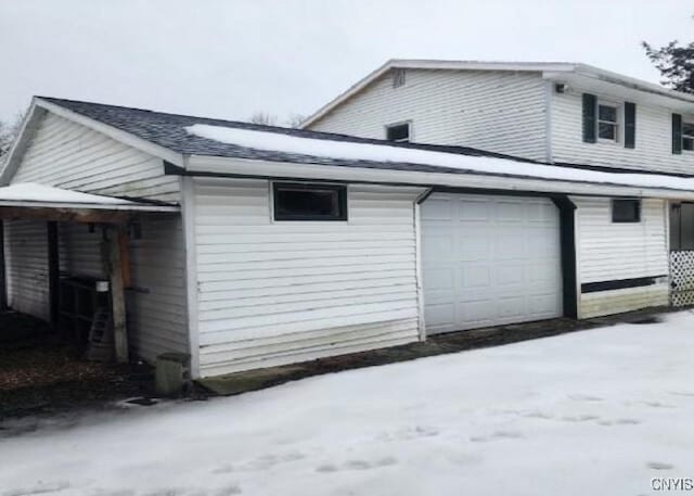 view of snow covered exterior with a garage