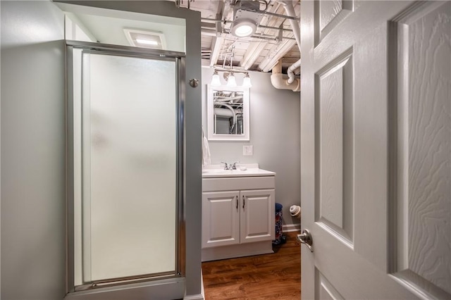 full bath featuring a stall shower, vanity, and wood finished floors