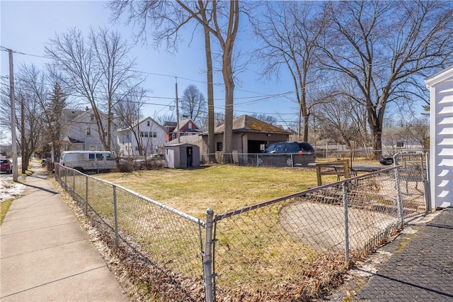 view of front of house with a front lawn, a residential view, fence private yard, a storage shed, and an outdoor structure