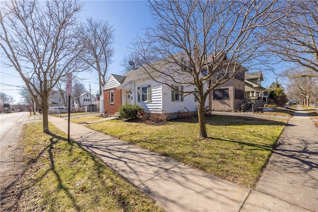 view of front of property with a residential view, brick siding, and a front yard