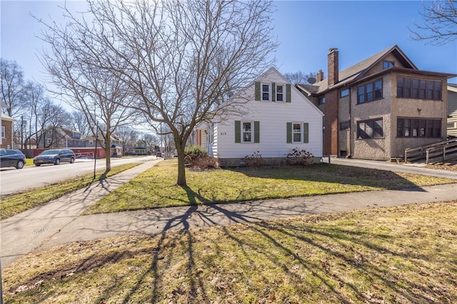 view of front of house featuring a front yard and a chimney