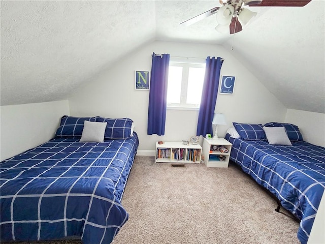 bedroom with lofted ceiling, a ceiling fan, carpet floors, and a textured ceiling