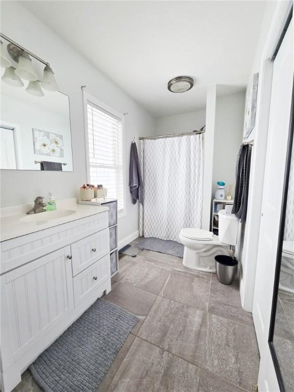 full bath with vanity, toilet, a shower with curtain, and baseboards