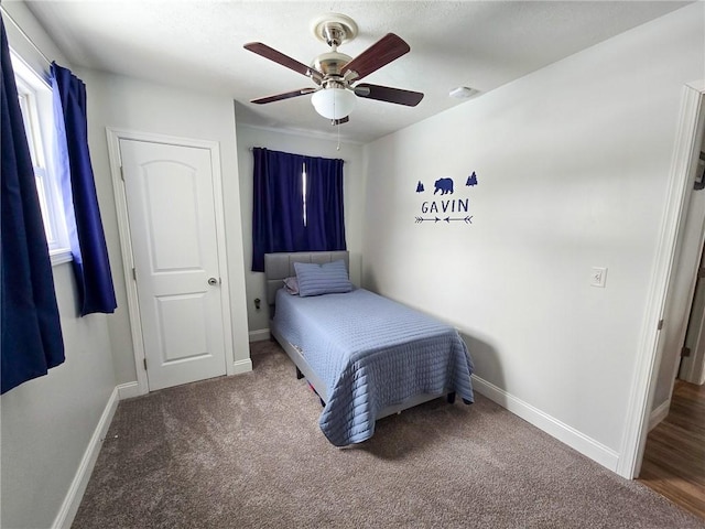 carpeted bedroom featuring a ceiling fan and baseboards