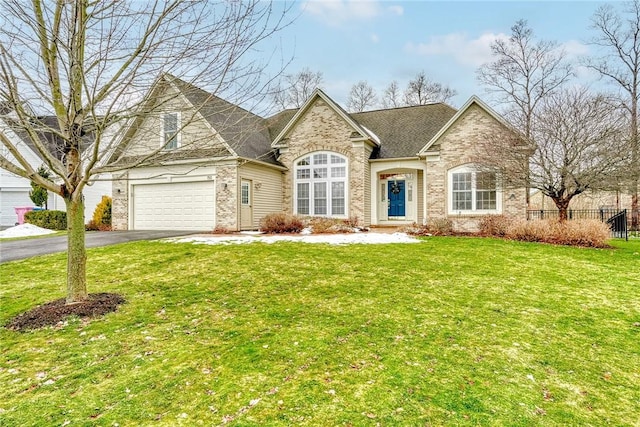 view of front of house with a front yard, fence, an attached garage, aphalt driveway, and brick siding