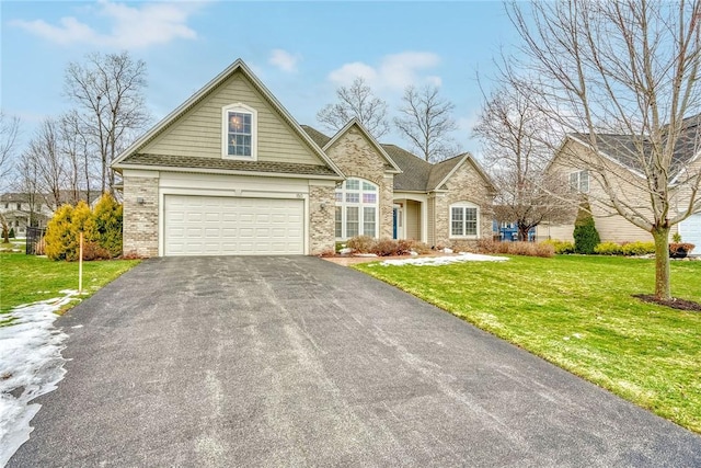 view of front of home featuring brick siding, a garage, driveway, and a front yard