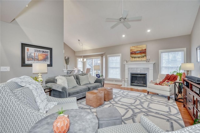 living area featuring a wealth of natural light, light wood-type flooring, and a premium fireplace