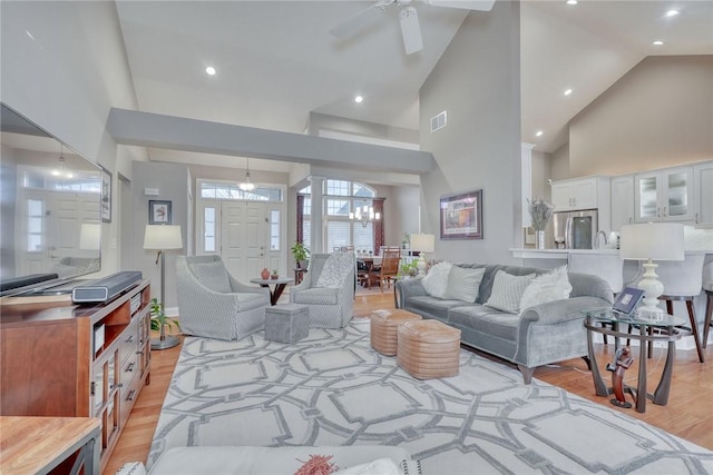 living area featuring recessed lighting, light wood-style floors, visible vents, and high vaulted ceiling