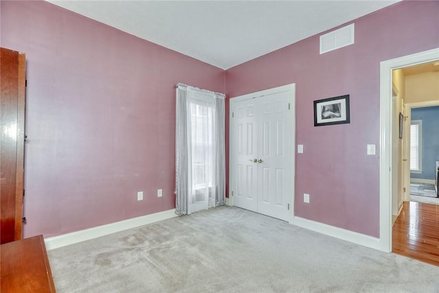 unfurnished bedroom featuring a closet, visible vents, baseboards, and carpet floors