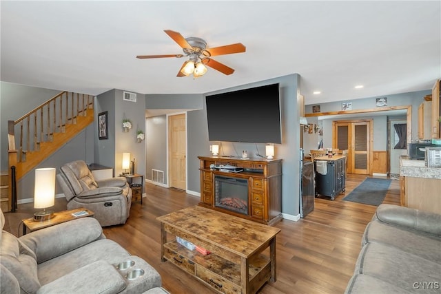 living area featuring stairway, wood finished floors, and visible vents