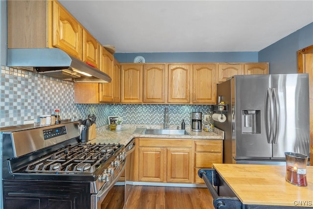 kitchen featuring butcher block countertops, a sink, backsplash, dark wood finished floors, and stainless steel appliances