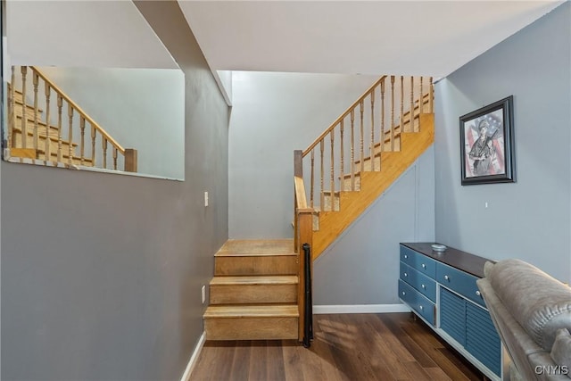 staircase with baseboards and wood finished floors