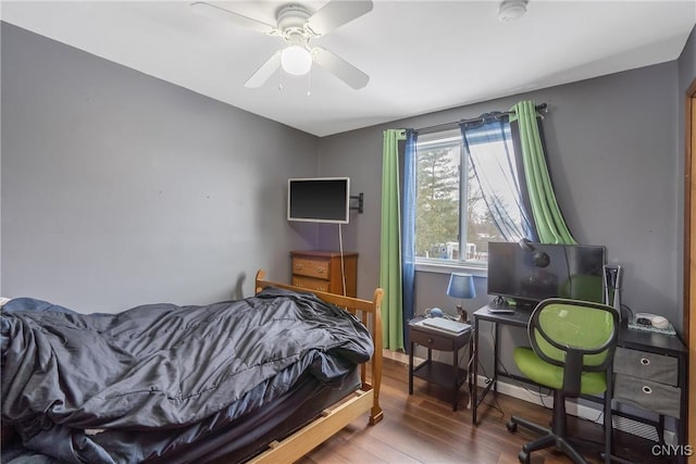 bedroom with wood finished floors, baseboards, and ceiling fan